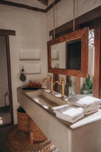 a bathroom with a sink and a mirror at Anacardier Privé Hotel in Atins