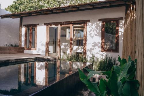a house with a swimming pool in front of it at Anacardier Privé Hotel in Atins