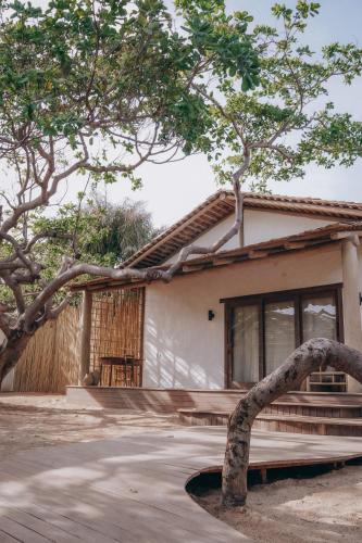 a house with a tree in front of it at Anacardier Privé Hotel in Atins