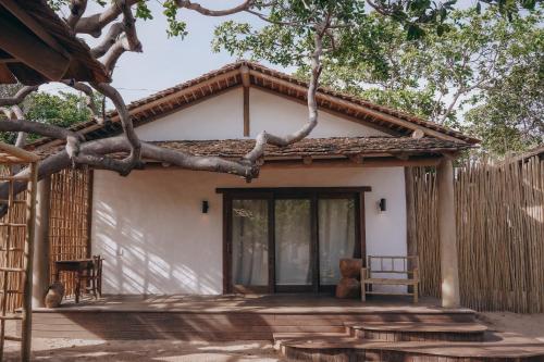 a small white house with a tree in front of it at Anacardier Privé Hotel in Atins