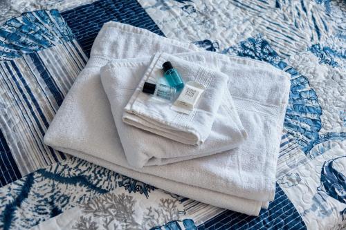 a white towel on a bed with a bottle on it at Genova Host - Una Finestra sul Mare in Genova