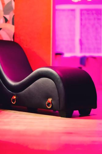 a black chair sitting on the floor in a room at Love room L'écrin tropical in Aubers