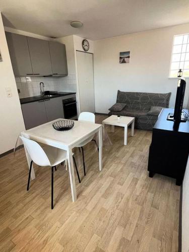 une cuisine et un salon avec une table et des chaises dans l'établissement Résidence Villa Anna - 077 - Appartement au 1er étage avec ascenseur MAE-4901, à Soulac-sur-Mer
