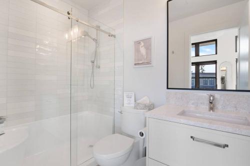 a bathroom with a toilet and a shower and a sink at Ocean's 7 at THE BEACH HOUSE in Campbell River