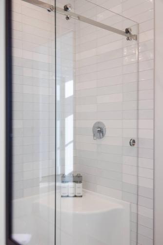 a bathroom with a glass shower with a sink at Ocean's 7 at THE BEACH HOUSE in Campbell River