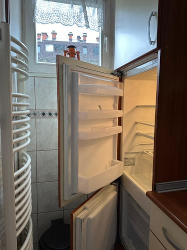 an empty refrigerator with its door open in a kitchen at Urban Nest in Jajce