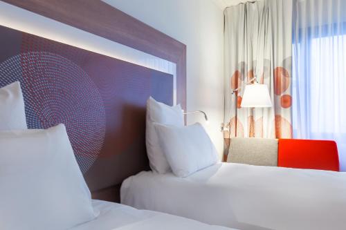 a hotel room with two beds and a window at Novotel Katowice Centrum in Katowice