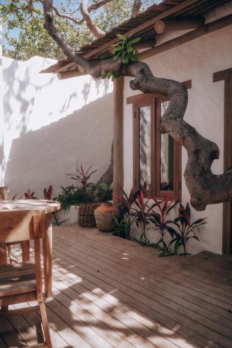 a wooden deck with a table and some plants at Anacardier Privé Hotel in Atins