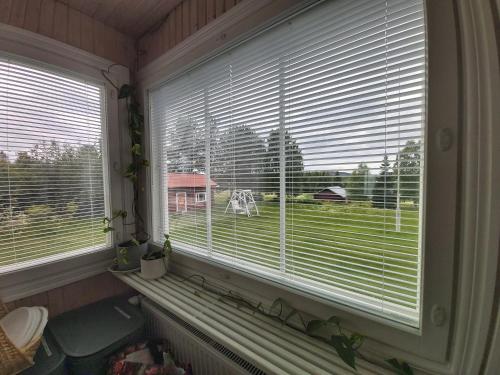 a window with blinds in a room with a view at Rooms in a big wooden home, kotimajoitus, homestay in Muonio