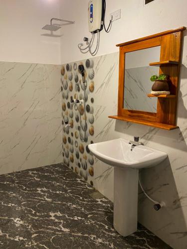 a bathroom with a sink and a mirror at Oasis Garden - Arugam Bay in Arugam Bay