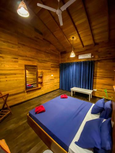 a bedroom with a large bed in a wooden room at Oasis Garden - Arugam Bay in Arugam Bay