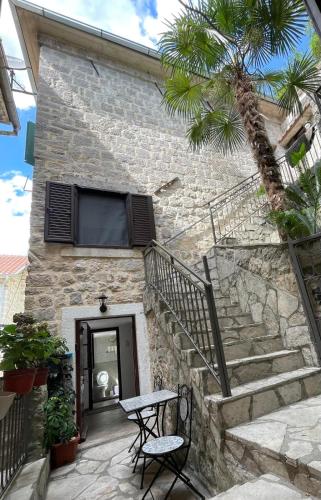コトルにあるKotor Old Town Cozy Escapeの階段とテーブルと椅子のある石造りの建物
