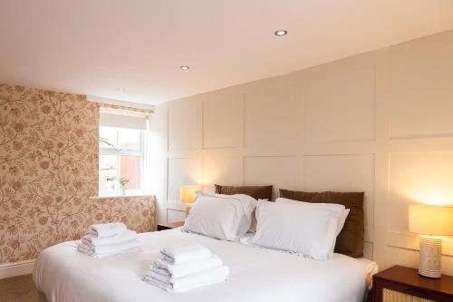 a bedroom with a bed with white sheets and pillows at Mill Cottage in Newlands