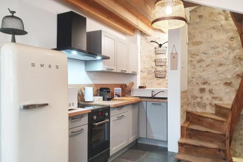a kitchen with white cabinets and a refrigerator at La Trouvillette - 500m plage - 10mn Gare in Trouville-sur-Mer