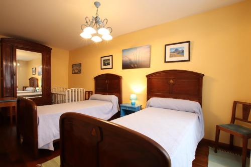 two beds in a room with yellow walls at Domaine Garmidou in Lucq-de-Béarn