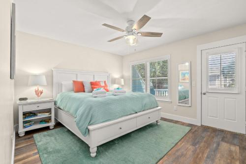 a white bedroom with a bed and a ceiling fan at 140 Feet To White Sandy Beaches! Newly Renovated! Pool! Grill! in Laguna Beach