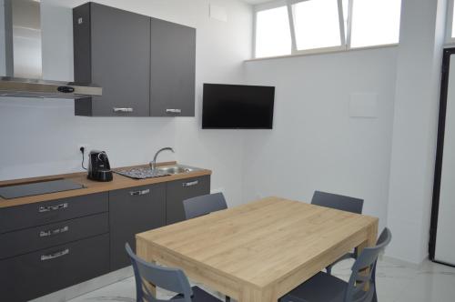 una cucina con un tavolo di legno e alcune sedie di La perla di Giada 1 a Bisceglie