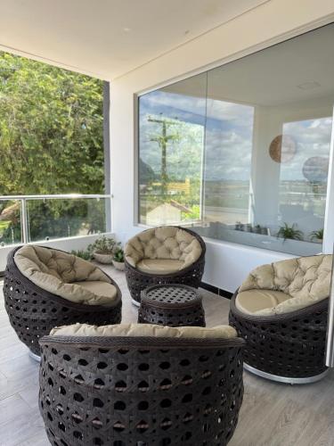 a living room with chairs and a table and a tub at Hotel Dois Montes in Itamaraju