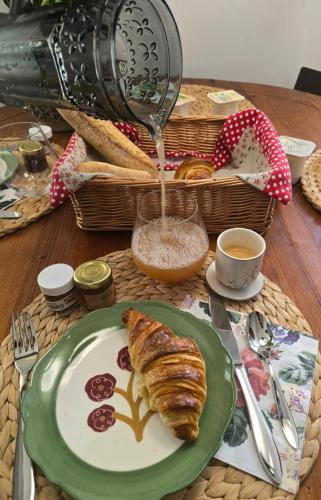 a table topped with a plate of bread and coffee at Lovely House in Besançon