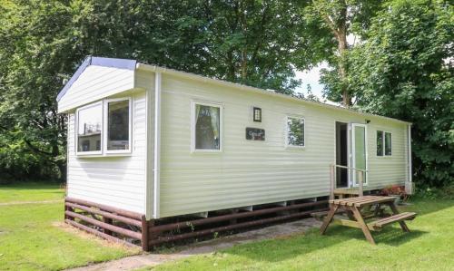 a small white tiny house in a yard at Caravan 6 - Blackmoor farm near tenby in Pembrokeshire