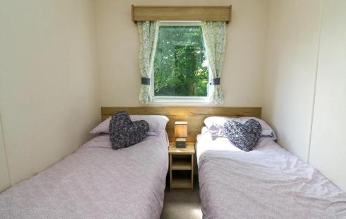 two beds in a small room with a window at Caravan 6 - Blackmoor farm near tenby in Pembrokeshire