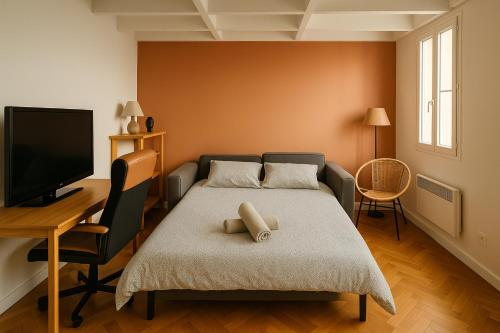 une chambre avec un lit, un bureau et une télévision dans l'établissement Home Sweet Home Champs Elysées Niel, à Paris