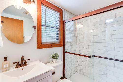 a bathroom with a shower and a sink and a mirror at Cartecay River Retreat with Yard and Screened Porch! in Ellijay