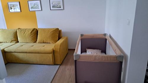 a living room with a couch and a crib at Apartman Lujzijana in Karlovac