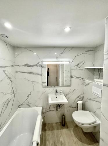 une salle de bain avec un lavabo, une baignoire et des toilettes dans l'établissement Cimiez studio aperçue Mer, à Nice