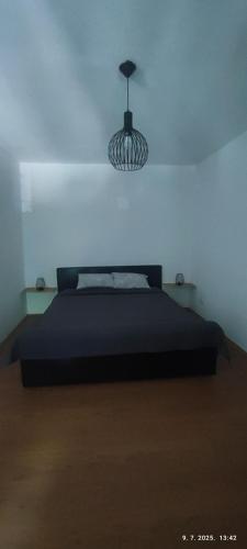 a bedroom with a black bed and a lamp at Apartman Dijana in Livno