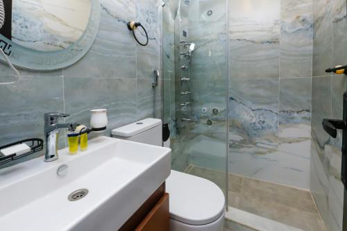 a bathroom with a toilet and a sink and a shower at Rotana Pyramids View in Cairo