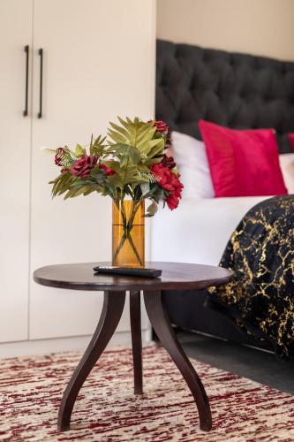 a coffee table with a vase of flowers on it at Casa Amora! in Mpemba