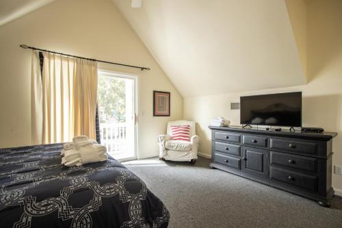 a bedroom with a bed and a dresser with a television at 48 Davis Love in Fripp Island