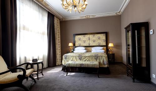 a bedroom with a bed and a chandelier at Heritage Boutique Hotel Sighisoara in Sighişoara