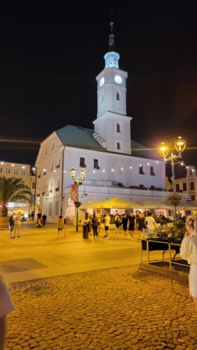 a large white building with a clock tower at night at Apartament Za Murami Gliwice in Gliwice