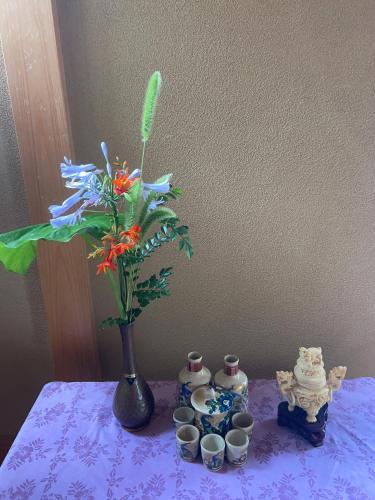 a purple table with a vase with a flower in it at SUZUNONE The only private lodging in Tokyo 2 min walk natural hot springs near BIG super market ASAKUSA AKIHABARA SKYTREE nearby Japanese TATAMI style in Tokyo