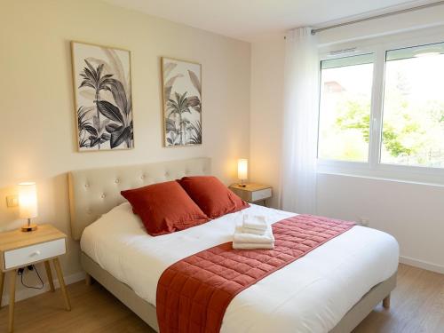 une chambre avec un lit avec des oreillers rouges et deux fenêtres dans l'établissement Cocon idylique, Clim, Lac et Montagnes, Jardin, à Saint-Jorioz