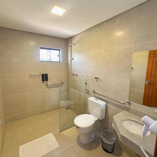 a bathroom with a toilet and a shower and a sink at Felipe Hotel in Serra Talhada