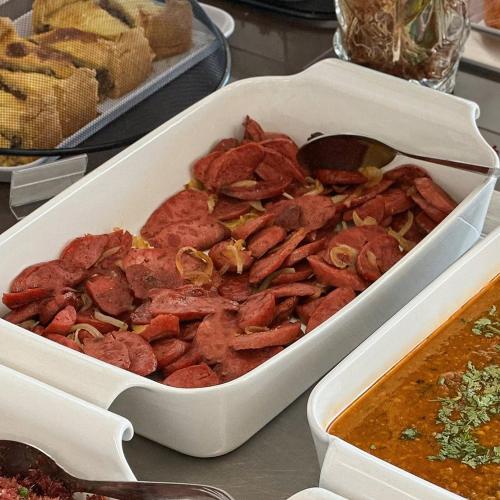 a white dish filled with meat and soup on a table at Felipe Hotel in Serra Talhada