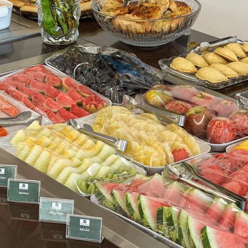 a buffet with many different types of fruit in trays at Felipe Hotel in Serra Talhada