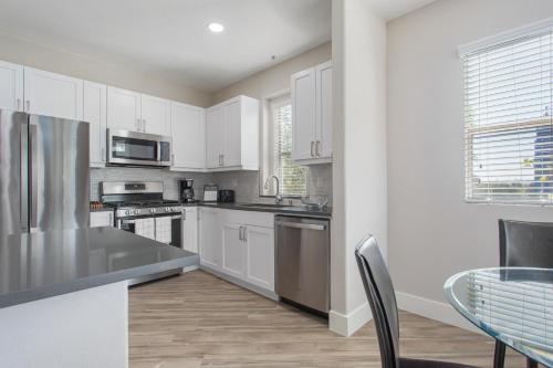 a kitchen with white cabinets and a table and chairs at Multiple Hollywood Apartments Hub in Los Angeles