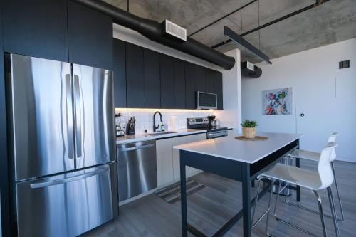 a kitchen with a stainless steel refrigerator and a table at Multiple Hollywood Apartments Hub in Los Angeles