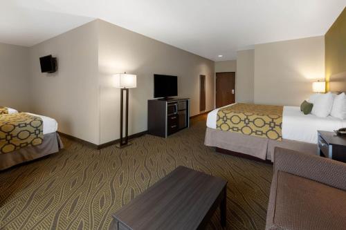 a hotel room with two beds and a flat screen tv at Baymont by Wyndham Beulah in Beulah