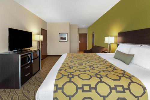 a hotel room with a bed and a flat screen tv at Baymont by Wyndham Beulah in Beulah