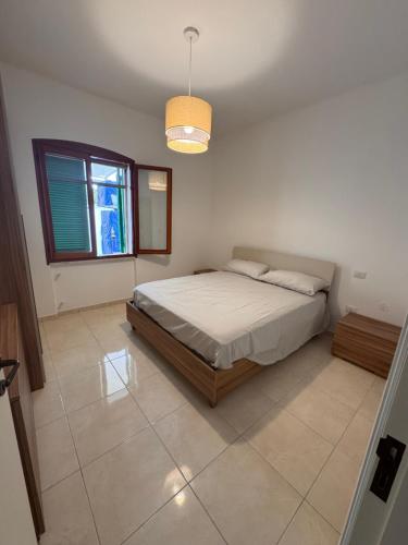 a bedroom with a bed and a window at Casa delle Mimose Baia Verde in Baia Verde