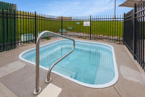 a swimming pool with a metal rail next to a fence at Baymont by Wyndham Beulah in Beulah