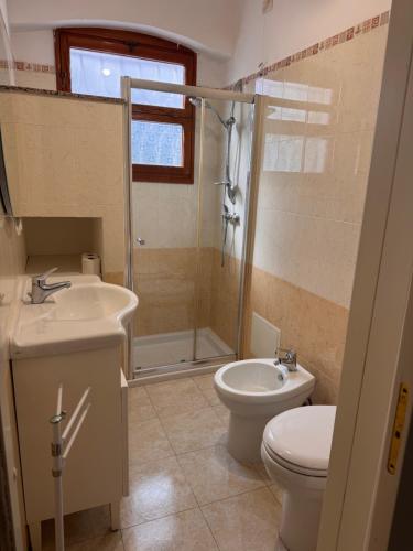 a bathroom with a toilet and a sink and a shower at Casa delle Mimose Baia Verde in Baia Verde