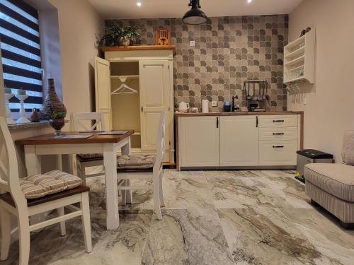 a kitchen with a table and chairs in a room at Apartament Suzi dla dwojga in Kruszyn