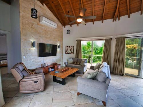 a large living room with couches and a tv at Spectacular Luxury Rental With Ocean Views And Private Pool in Roatan