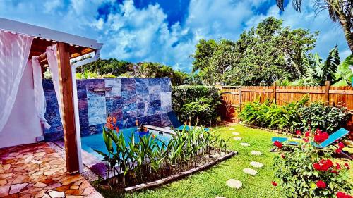 a backyard with a garden with a water feature at Géko, piscine, jardin, paisible in Sainte-Luce
